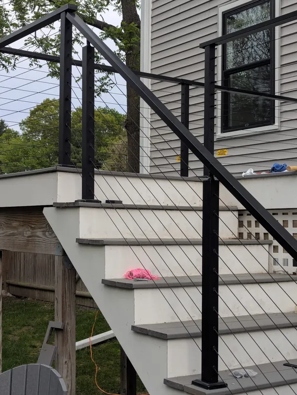 Black cable railing on an exterior staircase and porch