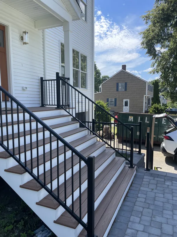 Black vertical-baluster railing along a wide outdoor staircase