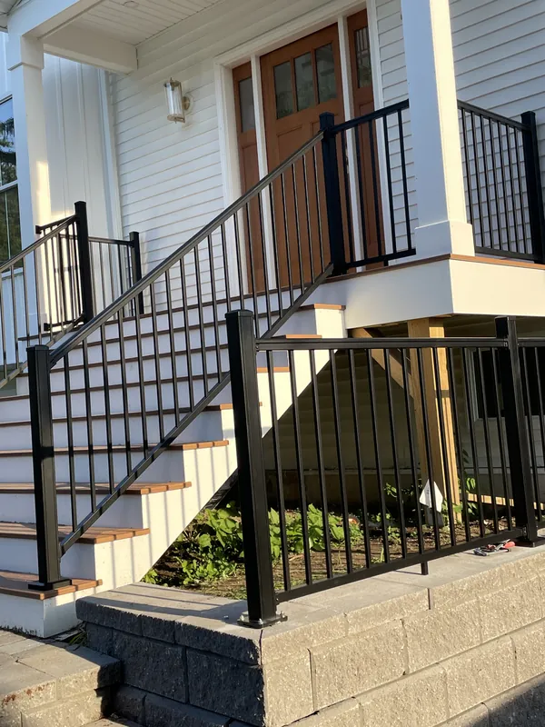 Black metal railing along exterior front steps and a porch