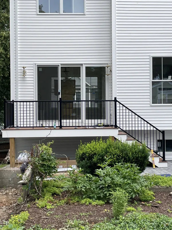 Black vertical-baluster railing around a raised porch