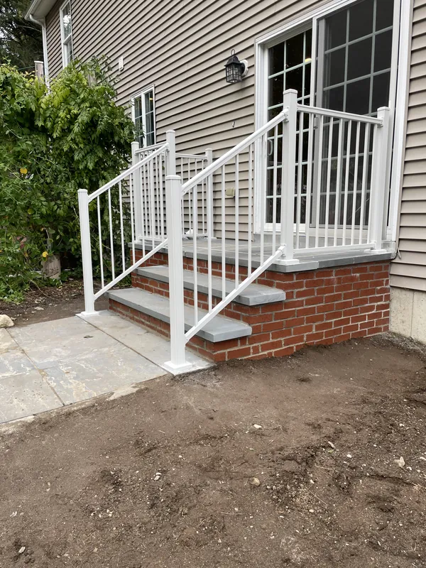 White railing around a raised entrance and exterior stairs